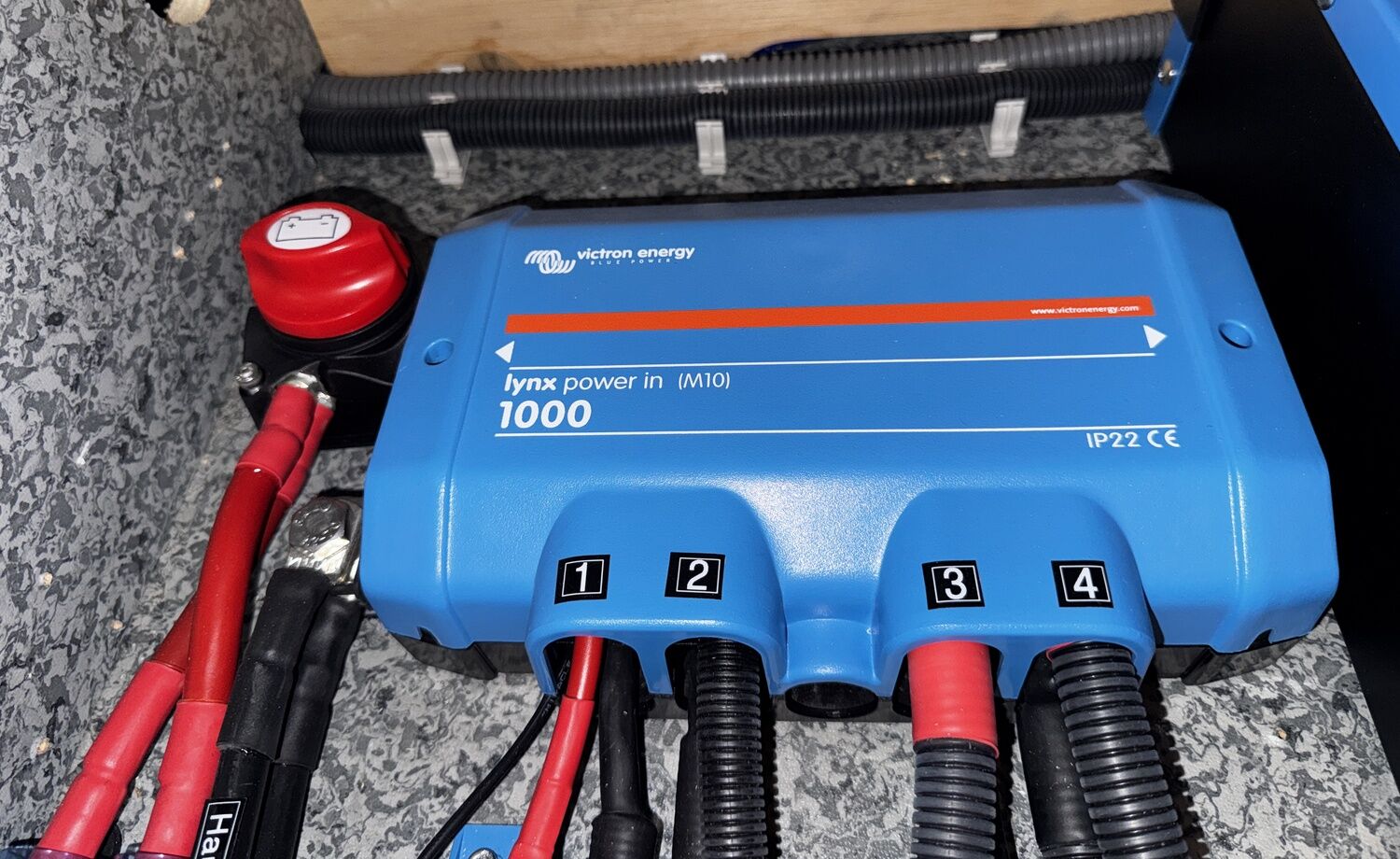 Victron Lynx Power In 1000 im Technikfach, links daneben der rote Batterietrennschalter